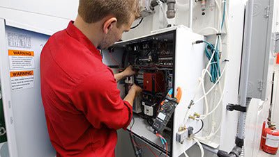 Spray booth service technician working in a Dallas auto body shop