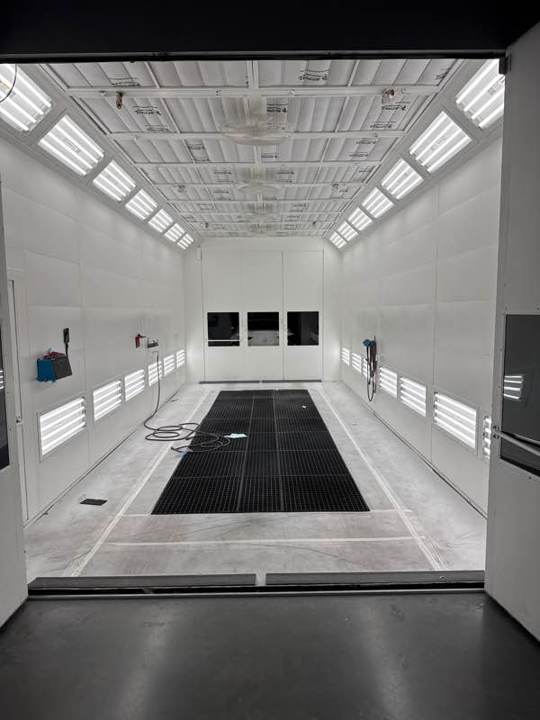 Clean downdraft paint booth with its doors open, ready for production