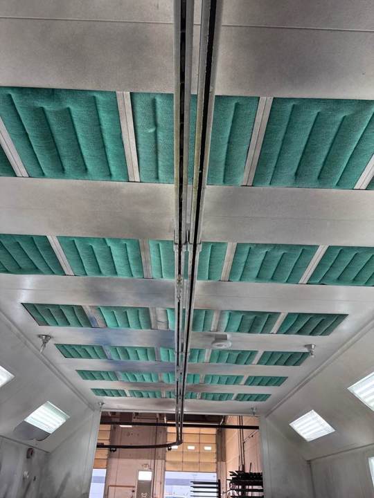Fresh green ceiling filters installed down the length of a downdraft paint booth